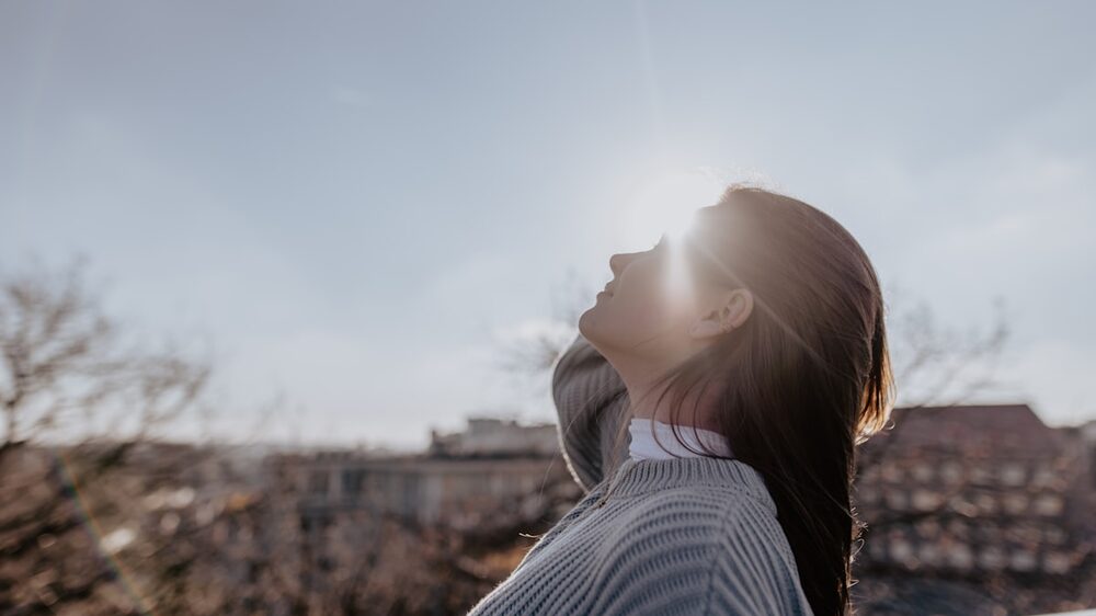Person soaking up sunlight &mdash; red light therapy for energy and vitality