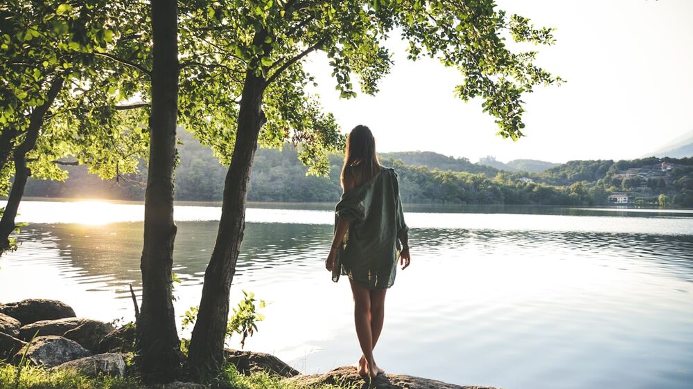 Woman by a calm lake &mdash; red light therapy and overall resilience