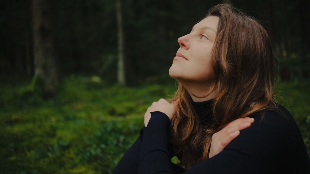 Calm woman in a quiet forest &mdash; red light therapy for mood and stress
